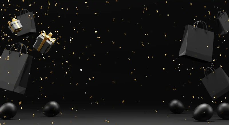 Black gift box with gold ribbon and bow, glossy finish.