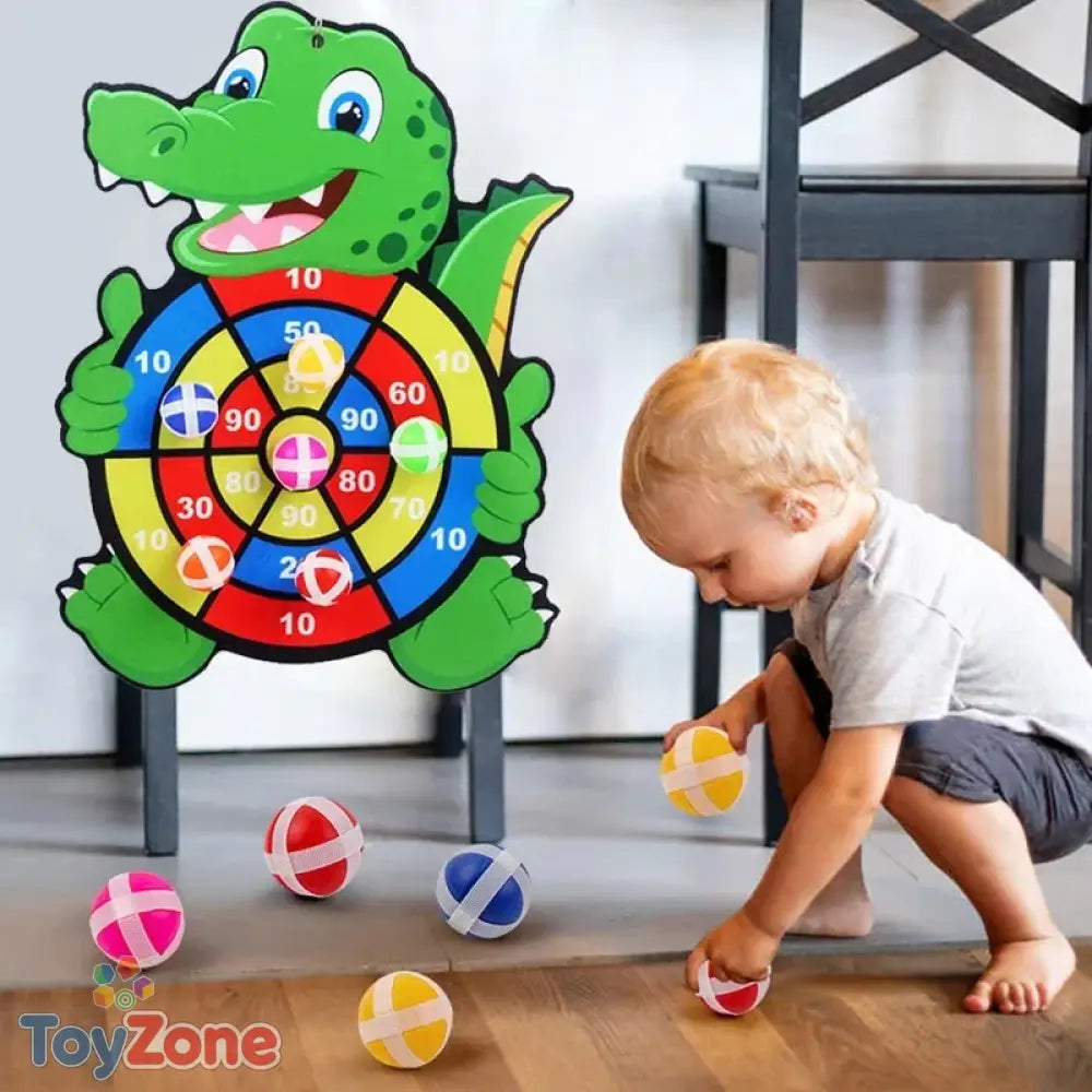 Child playing with educational sticky dart board toy indoor